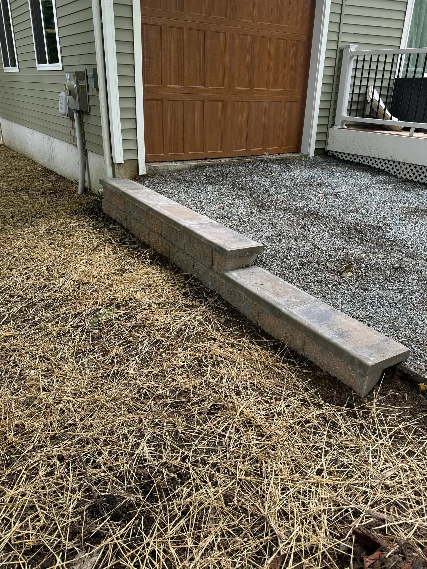 Gravel pad in front of a garage door, held in by a low block border