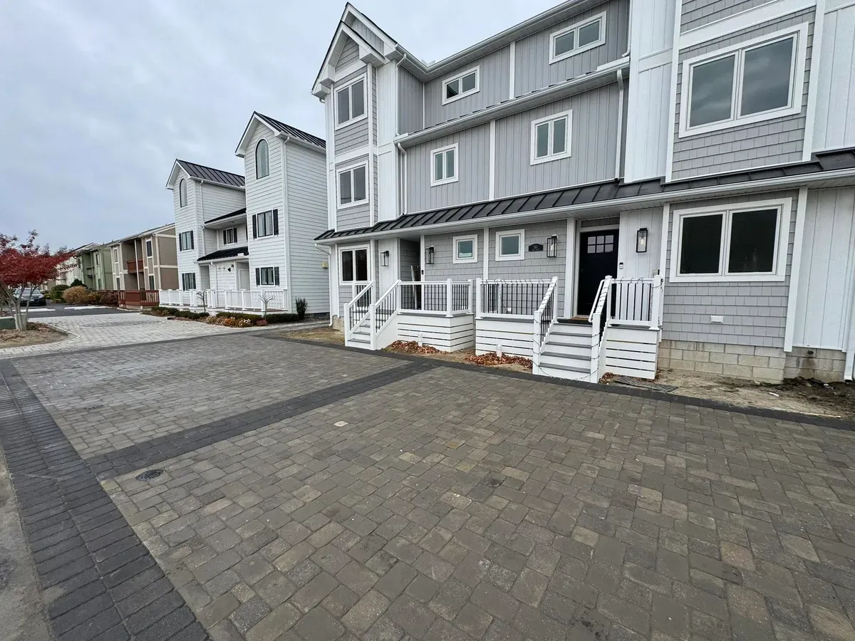 New paver parking area with a contrasting border in front of a row of townhomes